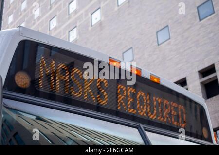 Message allumé sur l'en-tête du bus urbain indiquant masques Code requis 19 Banque D'Images
