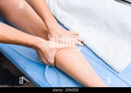 Vue de dessus du massage anti-cellulite du muscle gastrocnémien. Gros plan sur les mains du masseur. Banque D'Images