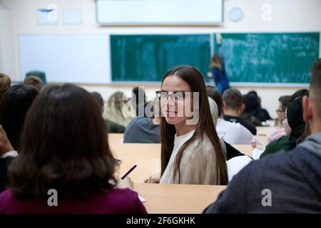 portrait d'une belle fille assise dans un amphithéâtre et parler à ses collègues pendant les cours Banque D'Images