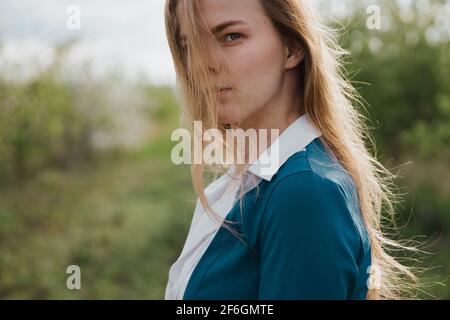 Une jeune femme regarde à travers ses cheveux à la visionneuse. Banque D'Images