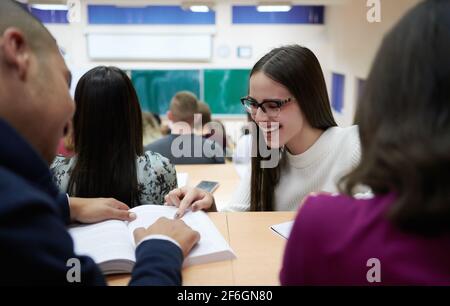 portrait d'une belle fille assise dans un amphithéâtre et parler à ses collègues pendant les cours Banque D'Images