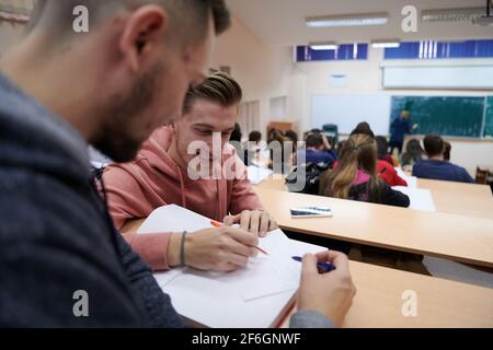 En classe élèves multiethniques à l'écoute d'un conférencier et à l'écriture dans des cahiers de notes. Smart Young People Study à l'université. Banque D'Images