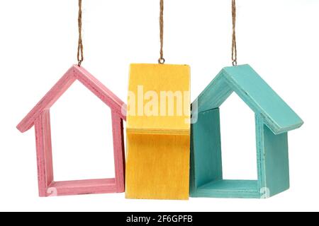 Maisons miniatures en bois suspendues par des cordes isolées sur fond blanc Banque D'Images