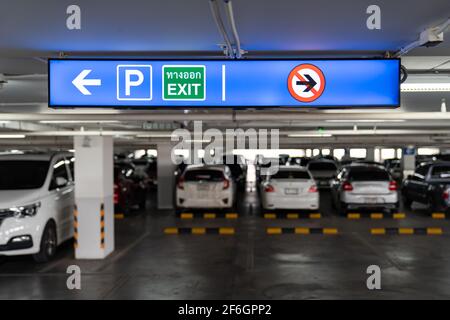 Signalisation la visionneuse dans le parking intérieur indique au conducteur la voie de stationnement ou de sortie. Langue thaï dans le carré vert sur la boîte d'éclairage signifie SORTIE. Banque D'Images