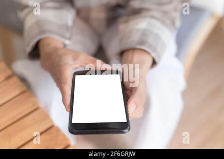 Gros plan femmes mains tenant smartphone, téléphone mobile, téléphone cellulaire avec écran blanc vierge pour l'espace de copie. Smartphone avec écran vide sur main femme Banque D'Images