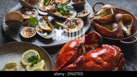 Fruits de mer frais moules, palourdes, crabes et escargots sur fond gris Banque D'Images