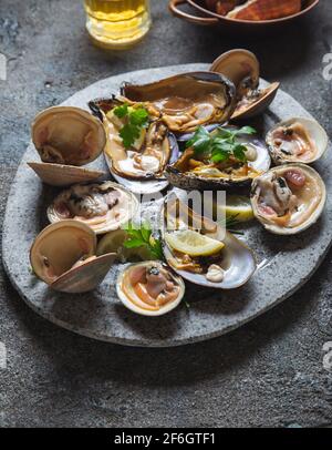 Fruits de mer frais moules, palourdes, crabes et escargots sur fond gris Banque D'Images