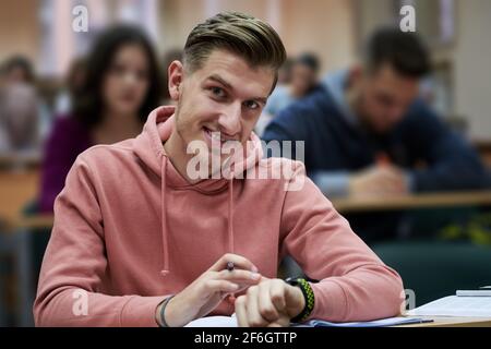 un jeune étudiant utilise une montre intelligente de tricherie dans un cours de mathématiques à l'université Banque D'Images