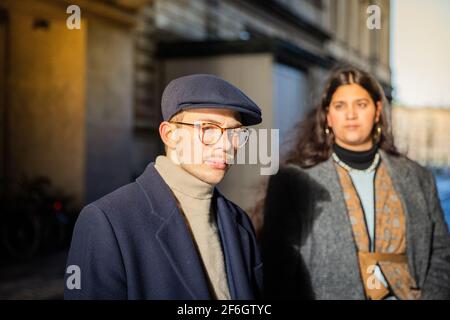 Portrait d'un jeune homme sérieux et élégant portant une casquette plate. Son ami est hors de foyer. Concept de jeunesse et de diversité Banque D'Images