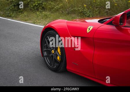 Le Front d'UNE Ferrari Red 2015 F12 Berlinetta avec Emblème de roue avant gris brillant sur la roue avant avec Étrier de frein jaune Banque D'Images