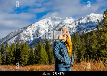 États-Unis, Idaho, Sun Valley, femme âgée souriante debout dans le paysage de montagne d'automne Banque D'Images