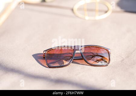 Lunettes de soleil classiques design pour hommes et femmes avec verres bruns et cadre brun Shoot à l'extérieur dans un jour d'été gros plan. Mise au point sélective Banque D'Images