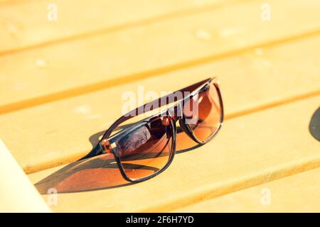 Lunettes de soleil classiques design pour hommes et femmes avec verres bruns et cadre brun Shoot à l'extérieur dans un jour d'été gros plan. Mise au point sélective Banque D'Images