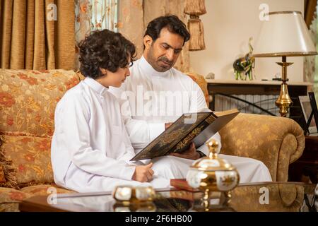 Père et fils arabes lisant le Saint Livre de Coran Banque D'Images