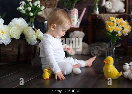 Mignon enfant blond, garçon avec décoration de pâques en studio, rampant sur le sol Banque D'Images