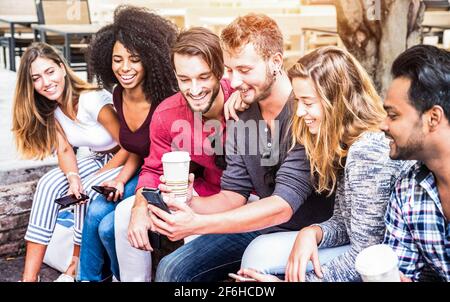 Groupe d'amis multiraciaux utilisant un smartphone à l'université - Young Les personnes dépendantes par téléphone mobile intelligent - concept de technologie Banque D'Images