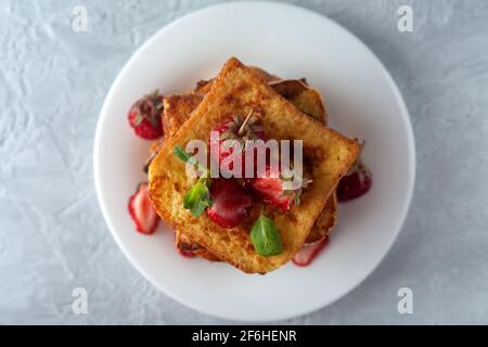 Pain grillé à la cannelle, aux fraises et à la menthe pour le café ou le thé. Petit-déjeuner le matin Banque D'Images