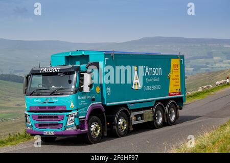 I'anson wagon transportant des aliments pour le bétail voyageant le long d'une route rurale étroite dans le North Yorkshire, Royaume-Uni. Banque D'Images