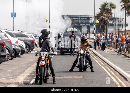 Cortège funéraire à Southend on Sea, Essex, Royaume-Uni, avec escorte de moto et d'autres effectuant une combustion fumée derrière le corbillard Banque D'Images