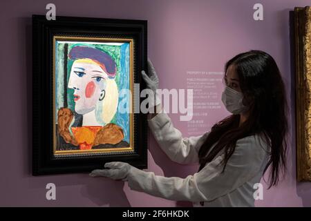 HONG KONG, CHINE : 1ER AVRIL 2021. Cristina Wang, spécialiste de l’art moderne et contemporain, ajuste le tableau de Pablo Picasso « Femme au Béret mauve » exposé à la Bonham Gallery de l’Amirauté Hong Kong avant sa vente à New York en mai 2021. La peinture de la plus grande muse de Picasso, Mare-Thérèse Walter, est en tournée mondiale pour attirer les acheteurs ayant été à Londres et Paris devant Hong Kong. Un prix de 15 millions de dollars US est estimé pour le chef-d'œuvre. Alamy Live News/Jayne Russell Banque D'Images