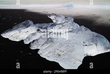 Morceau de glace sur la plage de diamants - lever du soleil sur Jökulsarlon glacier - Islande Banque D'Images