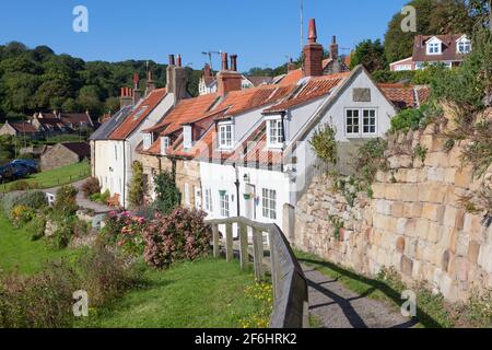 Belle vue d'été d'une rangée de chalets de pêcheurs traditionnels Dans le village de Sandsend sur la côte du Yorkshire du Nord Banque D'Images