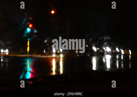 les feux de signalisation et les feux de voiture se reflètent sur une route inondée sous la pluie. Prises lors des inondations de Sydney en mars 2021. Banque D'Images