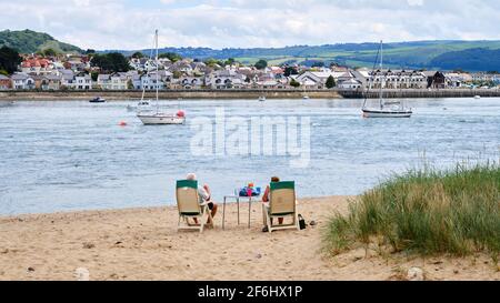 Un couple trouve l'endroit idéal pour profiter d'un pique-nique sur la plage et regarder l'activité sur la rivière Conway, au pays de Galles Banque D'Images