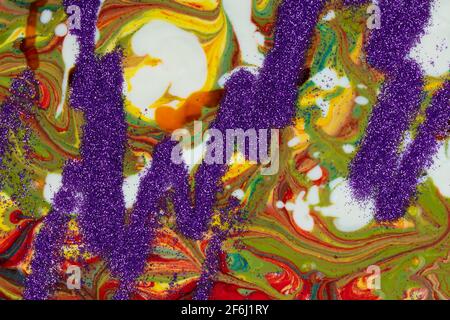 Un arrière-plan composé de nombreuses textures, formes et matériaux. Les sparkles violets sont dispersés sur un fond acrylique multicolore. Banque D'Images