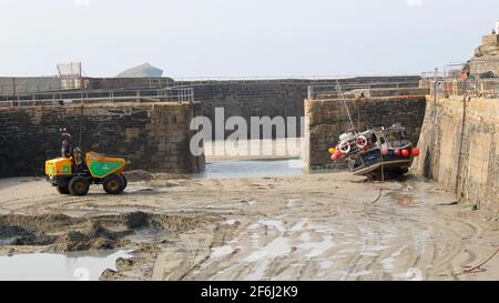 Tombereau de dragage engagé dans des opérations de dragage dans le port de Portreath. Banque D'Images