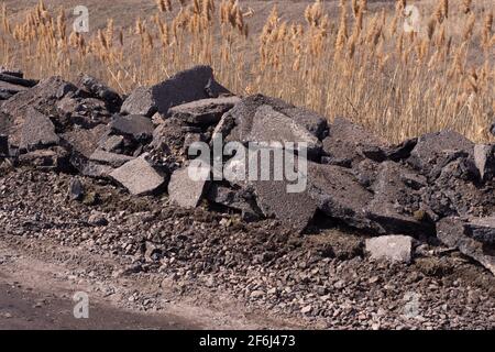 Morceaux d'asphalte vieux sur le côté de la route. Banque D'Images