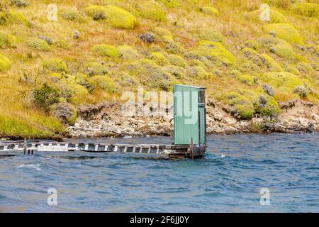 Bassin de toilettes extérieur vert au bord du lac, au bout d'une jetée en bois sur Languna Azul, parc national Torres del Paine, Patagonie, sud du Chili Banque D'Images