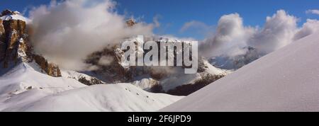 schöne Wolken und Schnee an den Felsen des Sella Massiv BEI Wolkenstein gegenüber vom Langkofel in Südtirol in den Dolomiten Italien Banque D'Images