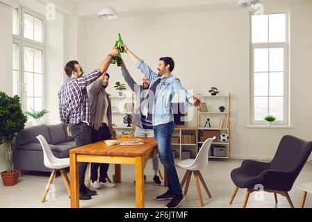 Groupe d'amis heureux de boire de la bière, de manger de la pizza et de profiter du bon temps ensemble Banque D'Images