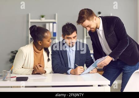 Conseiller financier et couple familial biracial signant un contrat Banque D'Images