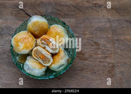 Une pâtisserie asiatique traditionnelle ou Tao SOR sur une table rustique en bois. Pâtisserie sucrée chinoise fourrée de pâte de haricots mung, de taro et d'œuf salé, l'un des populaires s. Banque D'Images