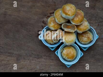 Une pâtisserie asiatique traditionnelle ou Tao SOR sur une table rustique en bois. Pâtisserie sucrée chinoise fourrée de pâte de haricots mung, de taro et d'œuf salé, l'un des populaires s. Banque D'Images