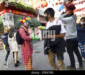 Londres, Angleterre, Royaume-Uni. Clown malheureux dans Chinatown Banque D'Images