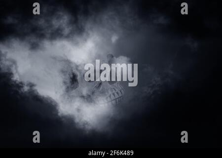 Composition Photo avec crâne et le trou de la lumière entre les nuages orageux sombres Banque D'Images