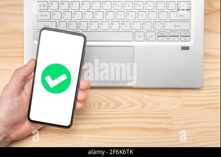 confirmation du téléphone cellulaire. Smartphone avec coche verte à l'écran, validé, confirmé, terminé, approuvé. Confirmation de la commande de smartphone. han Banque D'Images