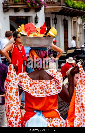 Cartagena, Colombie, centre-ville ancien clos, Centro, Playa de las Bovedas, arcade commerciale. Femme en costume traditionnel vendant des fruits dans le h Banque D'Images