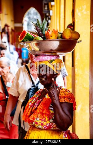 Cartagena, Colombie, centre-ville ancien clos, Centro, Playa de las Bovedas, arcade commerciale. Femme en costume traditionnel vendant des fruits dans le h Banque D'Images