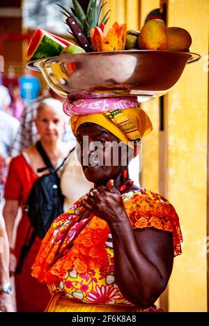 Cartagena, Colombie, centre-ville ancien clos, Centro, Playa de las Bovedas, arcade commerciale. Femme en costume traditionnel vendant des fruits dans le h Banque D'Images