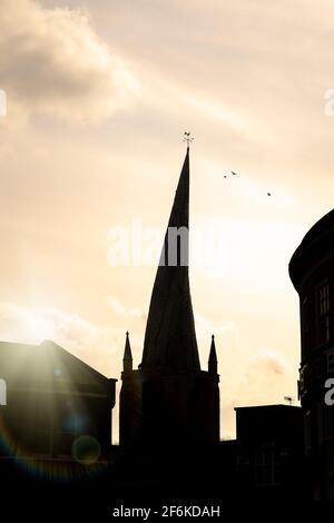 Chesterfield Crooked Spire église silhouette de tour dans le centre-ville avec coucher de soleil derrière et oiseaux dans le ciel coq-coq temps veine sur le dessus historique Banque D'Images