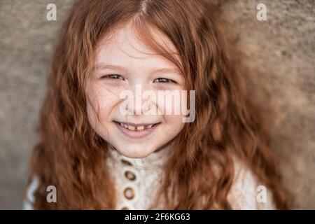 Portrait d'une jolie petite fille au gingembre en robe blanche Banque D'Images