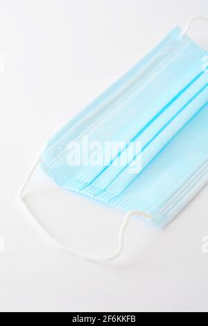 Masque chirurgical bleu (actuellement protégeant contre le coronavirus Covid-19) sur fond blanc. Banque D'Images