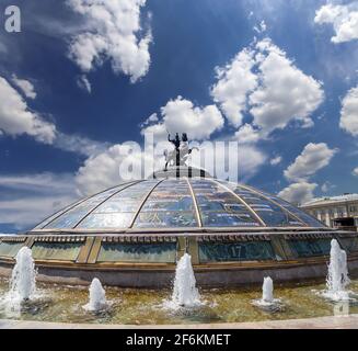 Place Manège (coupole de verre couronnée par une statue de Saint George, Saint patron de Moscou) sur fond de nuages. Inscription en russe: Noms de célèbres Banque D'Images