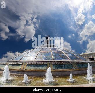 Place Manège (coupole de verre couronnée par une statue de Saint George, Saint patron de Moscou) sur fond de nuages. Inscription en russe: Noms de célèbres Banque D'Images
