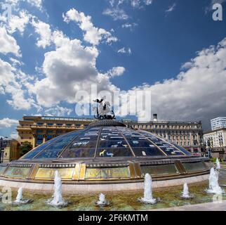 Place Manège (coupole de verre couronnée par une statue de Saint George, Saint patron de Moscou) sur fond de nuages. Inscription en russe: Noms de célèbres Banque D'Images