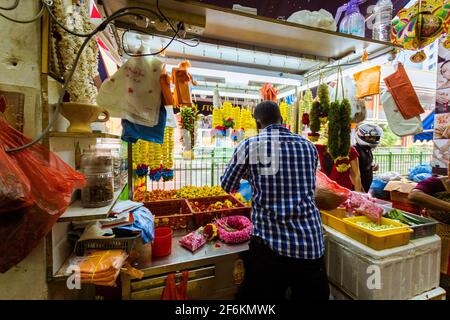 Little India, Singapour - 27 décembre 2013 : Un homme vente de guirlandes dans une stalle dans une rue de Little India, à Singapour. Banque D'Images